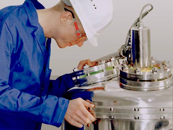A worker uses a flange sight glass for observation.