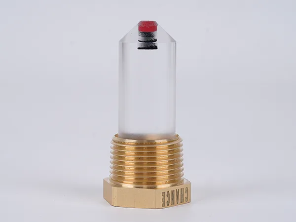 The reflex oil level gauge with a nut is positioned upright on the table.